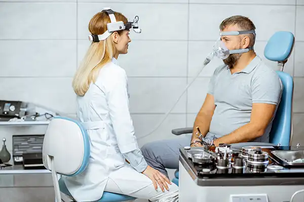 Doctor assesses a patient with a CPAP sleep apnea machine attached to his face